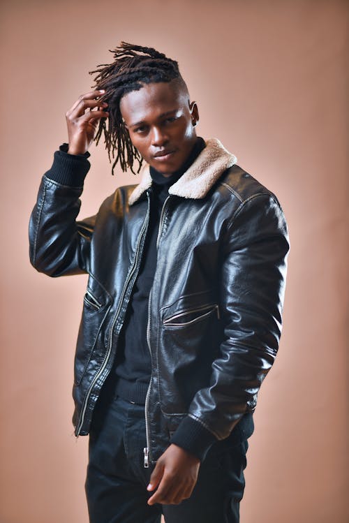 Free Man in a Black Leather Jacket Looking at the Camera while Touching His Hair Stock Photo