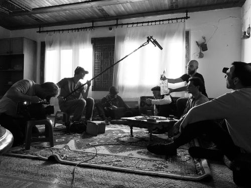 Free Film crew working indoors on a video shoot, capturing behind-the-scenes action. Stock Photo