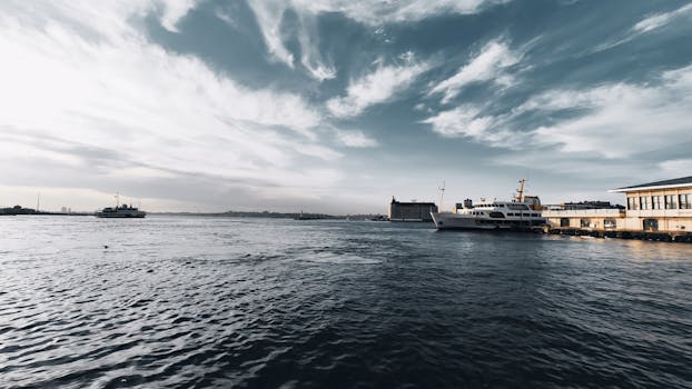 A stunning view of ferries on the ocean front under a dramatic sky at sunset, capturing transportation and nature's beauty.