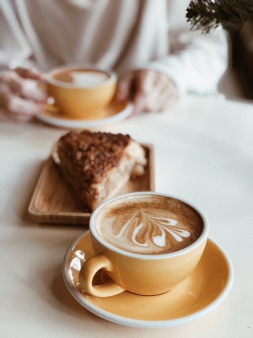Free Cup of latte near piece of cake in coffee shop Stock Photo
