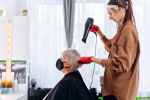 Master drying hair of client in salon