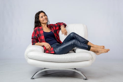 Woman in a Black and Red Plaid Shirt Posing on a White Chair