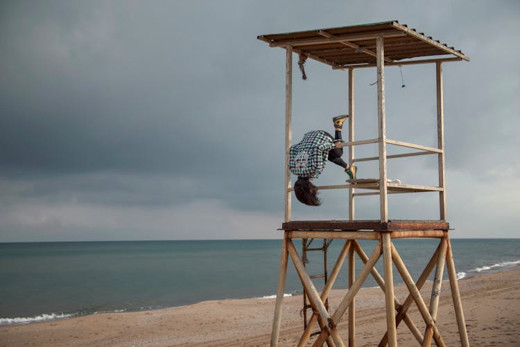 Anonymous Kid Doing Somersault On Lifeguard Tower