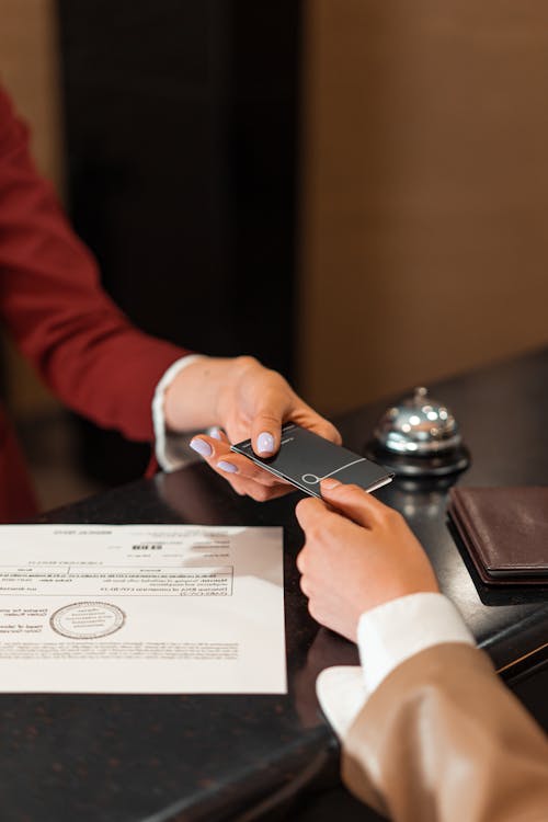 Hotel receptionist handing key card to guest