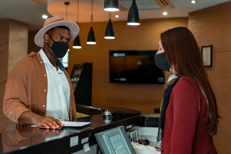 Man Wearing A Face Mask Checking In A Hotel 