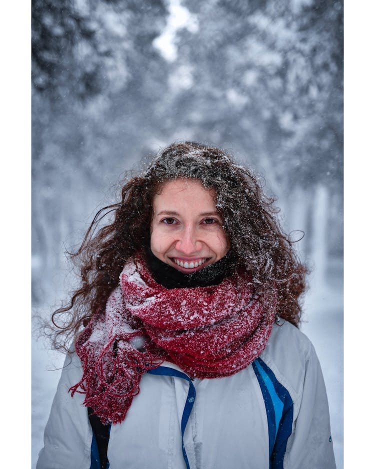 Portrait Of A Woman With A Red Scarf Covered In Snow