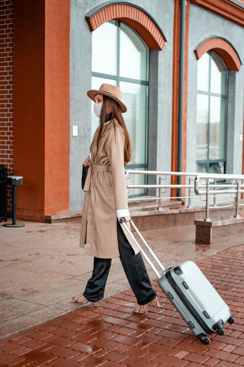 Free Fashionable woman in coat and hat walking with luggage, travel concept Stock Photo