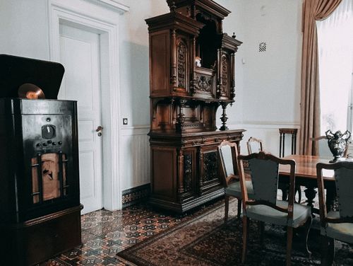 Free Vintage dining room interior featuring an ornate wood cabinet and gramophone with antique decor. Stock Photo