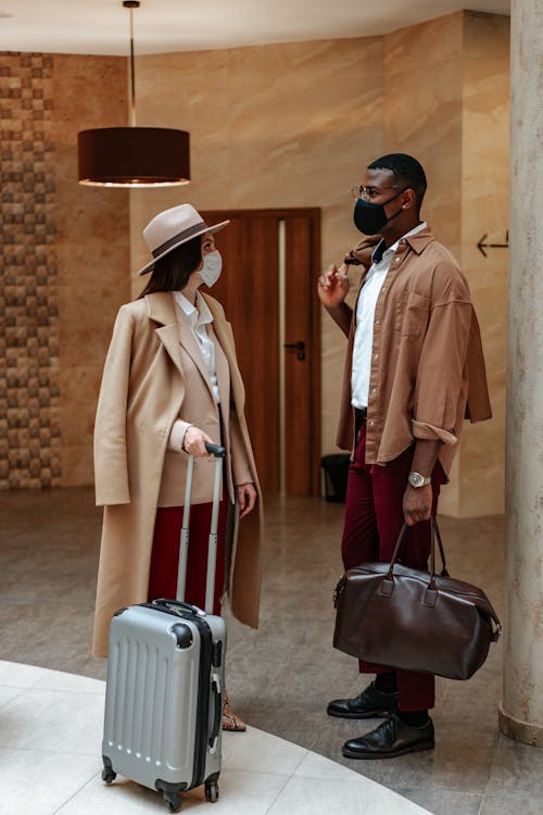 Photo Of A Man With A Brown Bag Talking To A Woman Beige Coat