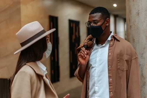Free Two people wearing face masks having a conversation indoors. Modern lifestyle. Stock Photo