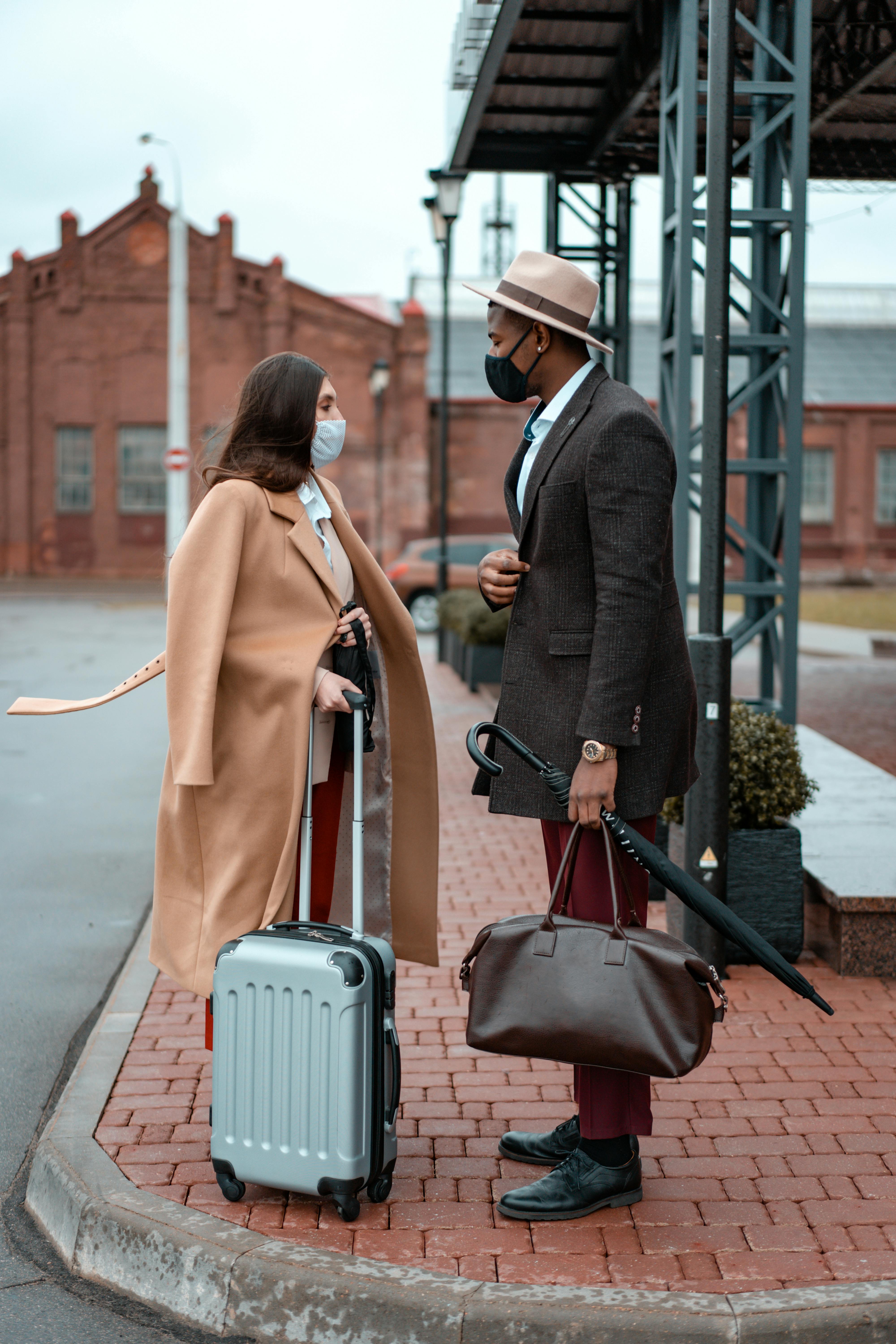photo of a woman in a beige coat talking to a man with a hat