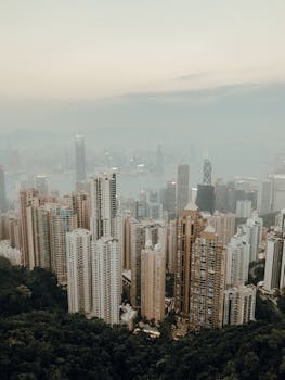 Aerial view of Hong Kong Island's skyline on a foggy day, highlighting skyscrapers and urban architecture.