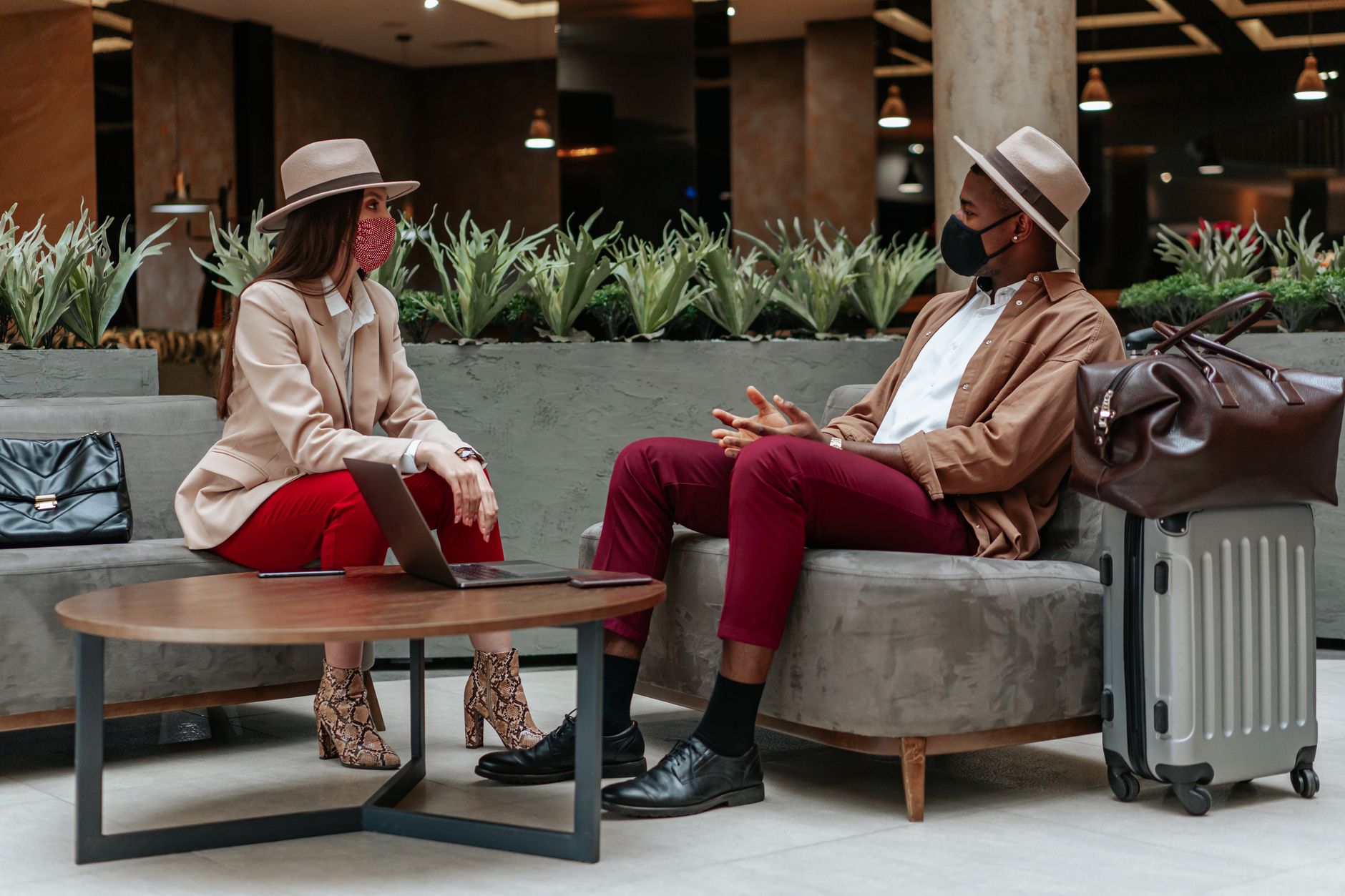 Caucasian woman and Black man meeting in hotel lobby wearing face masks. Related image for Revenue and Distribution: Why Independent Hotels Are Investing Now.