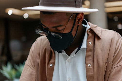 Free Close-Up Photo of a Man in a Brown Shirt Wearing a Black Face Mask Stock Photo
