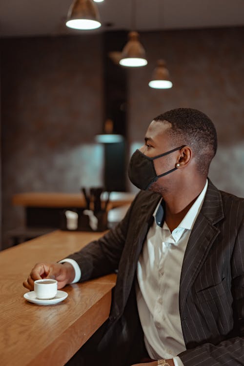 Man Wearing Face Mask Holding a Cup