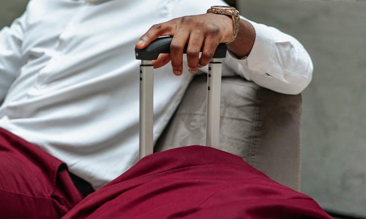 A Person's Hand Holding A Suitcase Handle