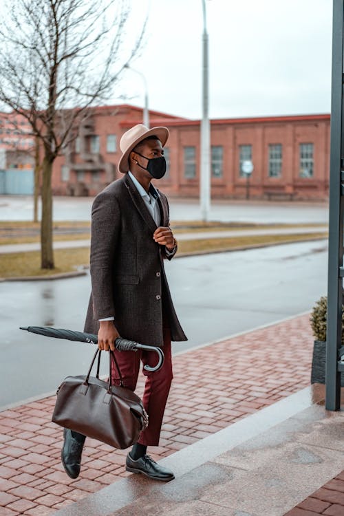 Man Wearing a Coat Walking on the Doorway · Free Stock Photo
