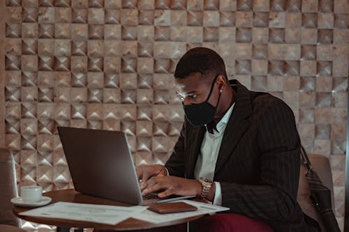 Man in Black Suit Jacket Using a Laptop 