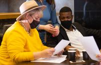 Man in Yellow Sweater Sitting Beside Woman in White Long Sleeve Shirt