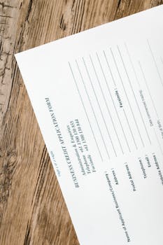 A business credit application form resting on a rustic wooden table, ready for completion.