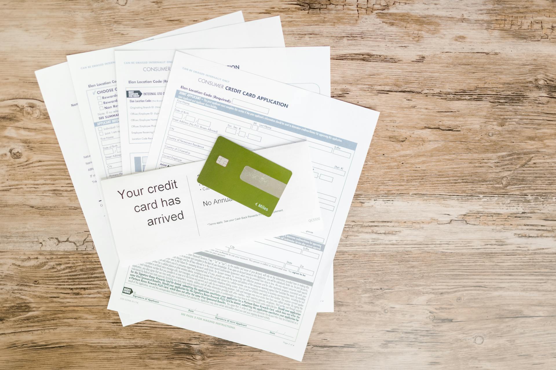 Green Credit Card on Top of Papers