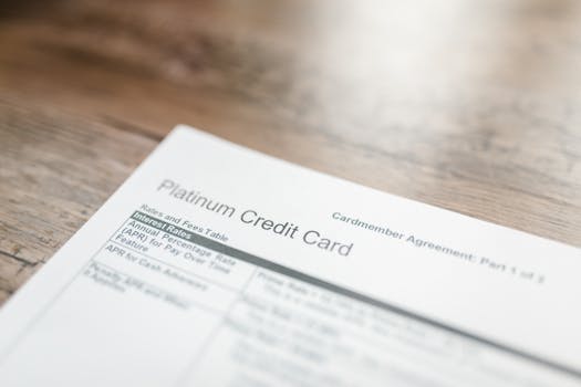 Photo by RDNE Stock project Close-up of a platinum credit card document with interest rates table on a wooden surface.