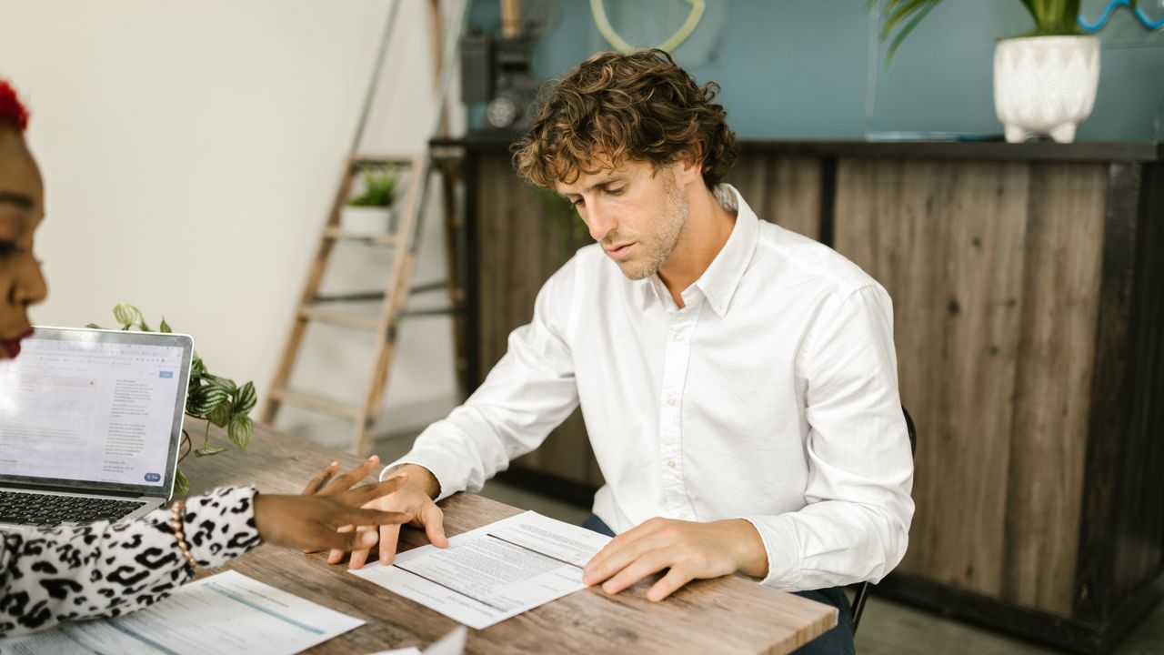 Two professionals discussing financial documents in an office setting.
