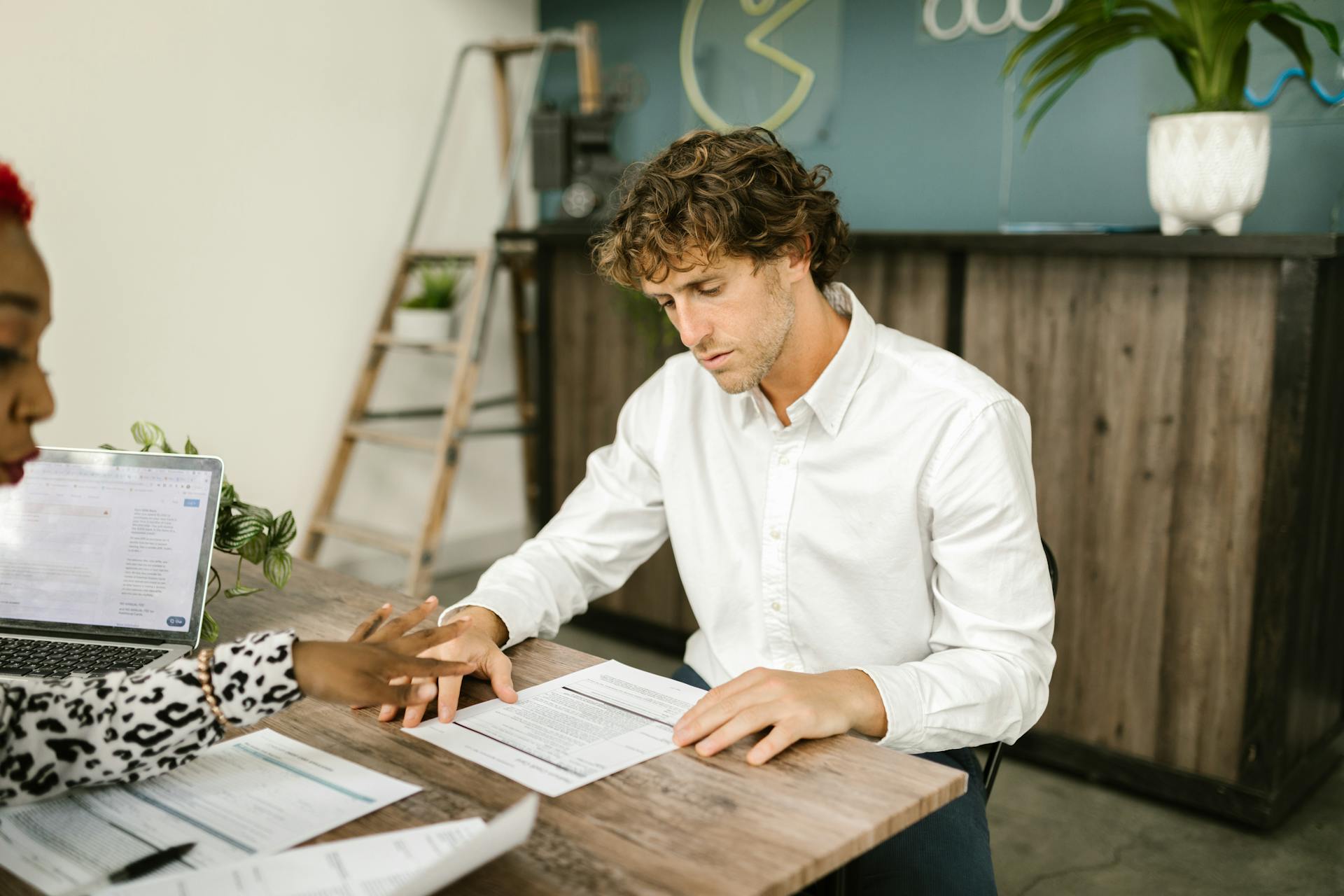 Two professionals discussing financial documents in an office setting.