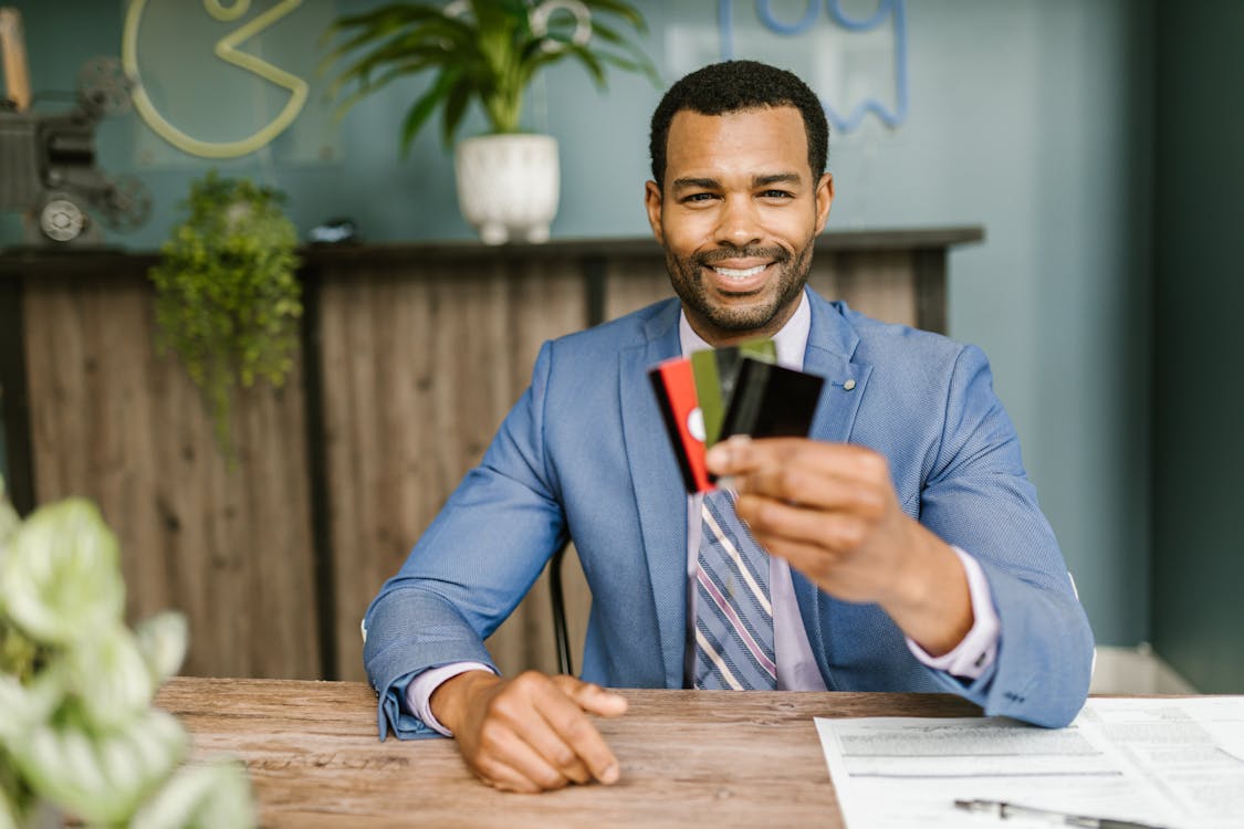 Free A Man In A Suit Holding Credit Cards Stock Photo