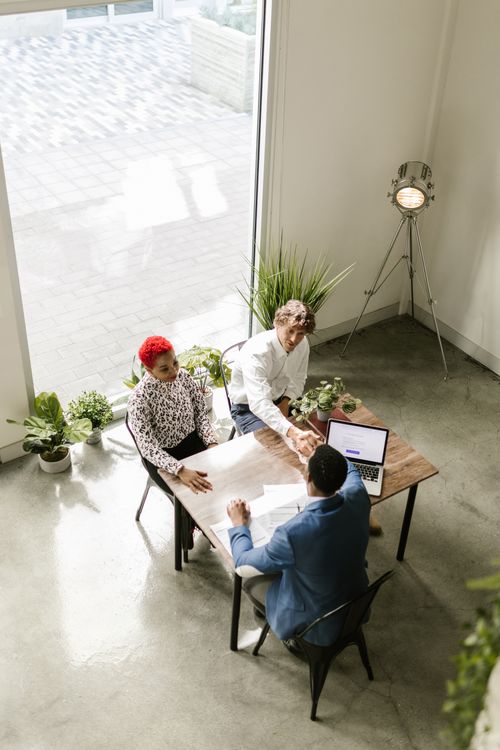 Free High angle view of a diverse business team concluding a meeting with a handshake, indoors. Stock Photo