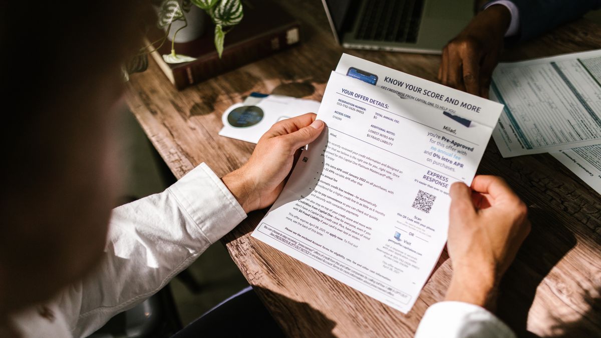 Printed credit report documents on a desk with a pen