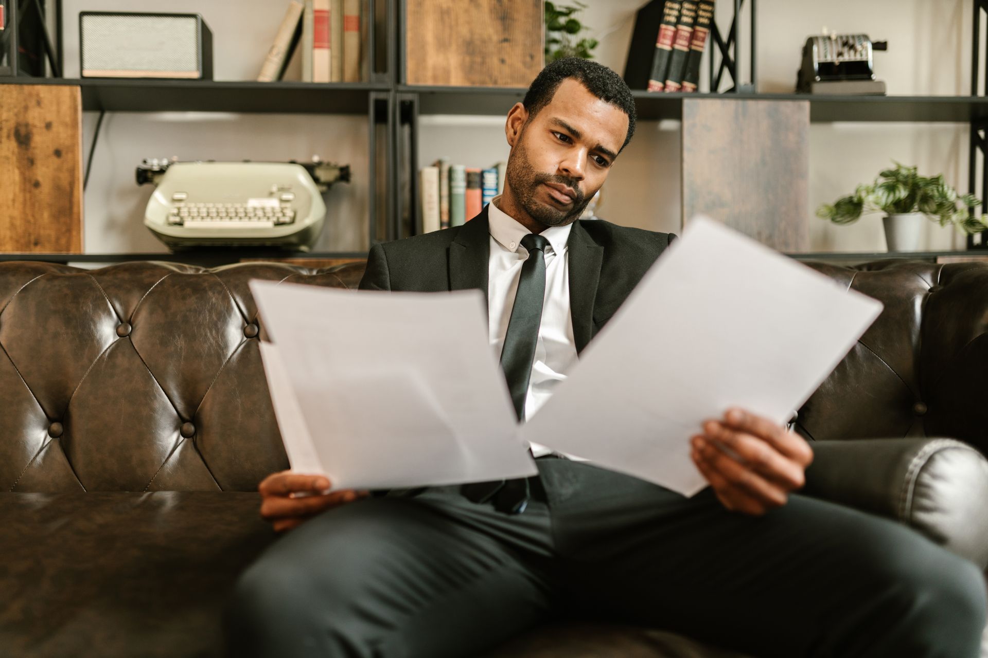 A Man in a Suit Looking at Documents