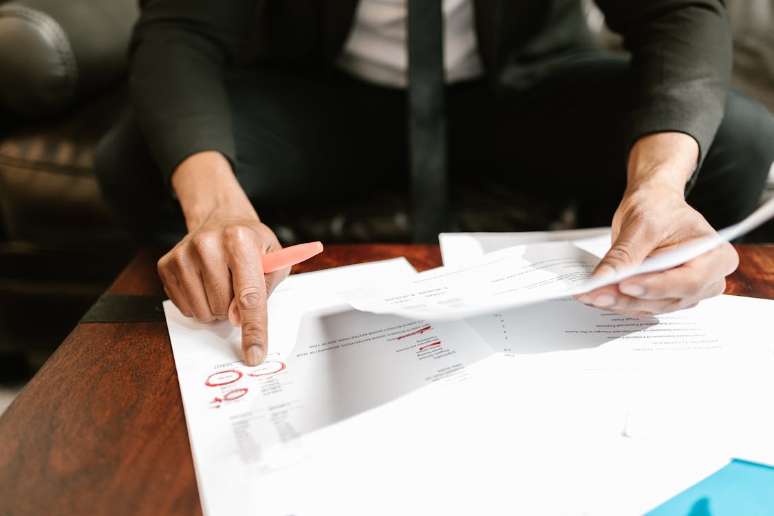 Free Close-up Photo of Person pointing on Documents  Stock Photo