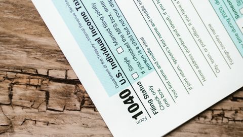 A close-up view of a 1040 US Individual Income Tax Return form on a wooden surface.