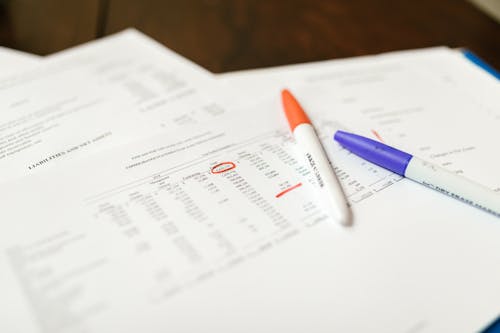 Free Close-up Photo of a Document with Pens on Top  Stock Photo