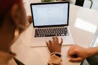 Close-Up Shot of a Person Filling out a Form Using a Laptop