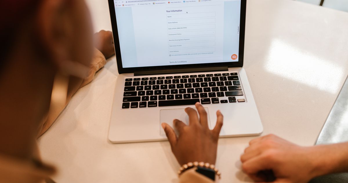 Person füllt am Laptop ein Onlineformular aus: kurzes Anfrageformular auf der Landingpage
