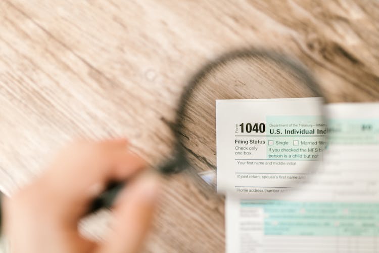 Close-Up Shot Of A Document Through A Magnifying Glass 