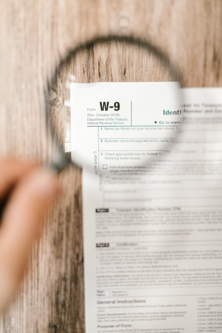 Close-Up Shot Of A Document Through A Magnifying Glass 