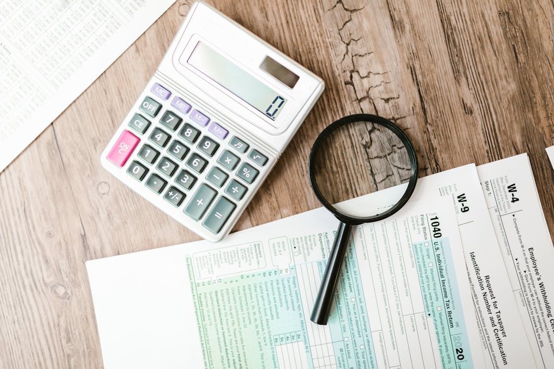 Free A Calculator and a Magnifying Glass beside Documents Stock Photo