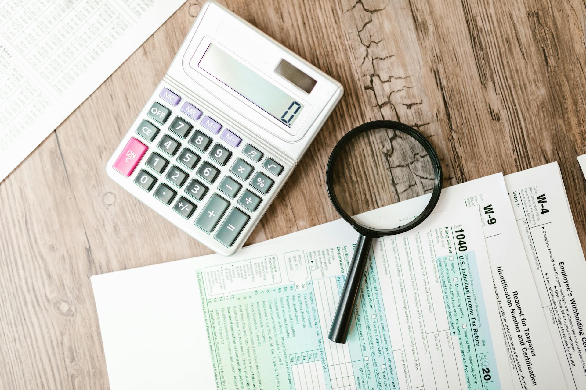 A Calculator and a Magnifying Glass beside Documents