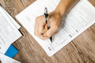 Close-Up Shot of a Person Filling Out a Form