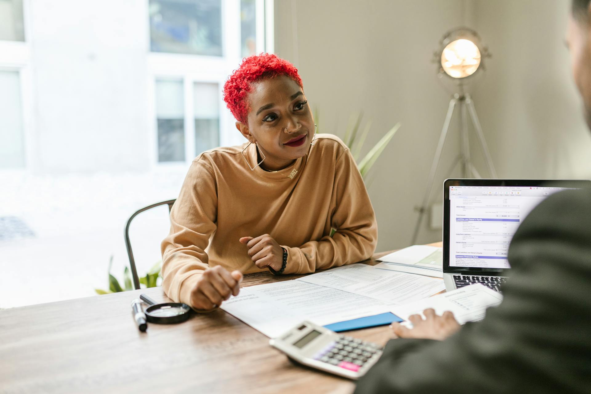 Professional woman engaged in thoughtful discussion at a business meeting indoors.