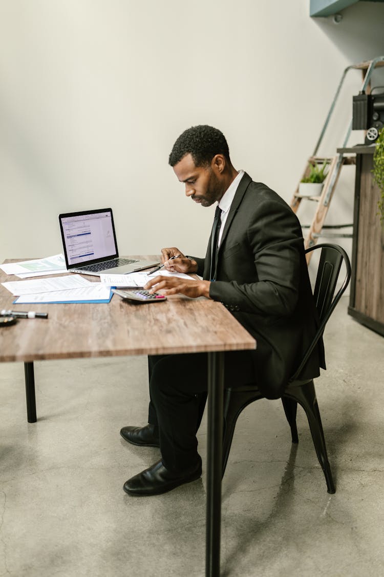 A Man In Corporate Attire Doing His Taxes