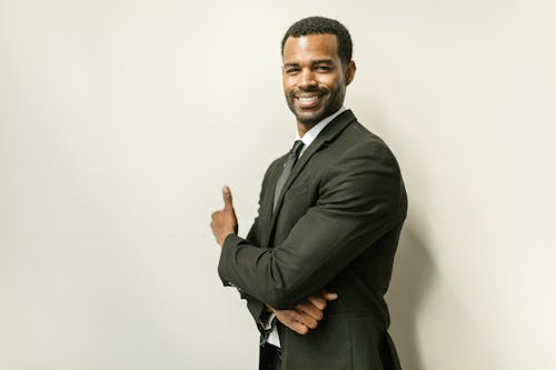 Free A Man in Black Suit Smiling while Looking at the Camera Stock Photo