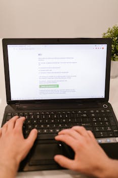 Close-up of hands typing on laptop keyboard, focusing on online payment verification.