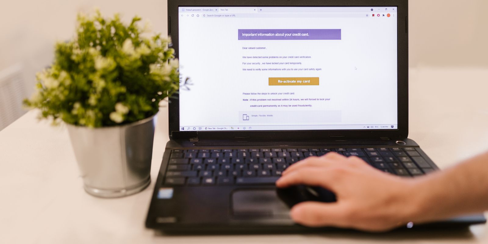 A hand using a laptop trackpad with a webpage open showing a highlighted button
