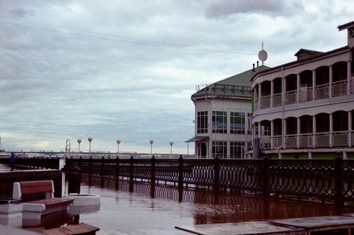 Free Beautiful riverfront architecture with overcast sky and reflections on water. Stock Photo