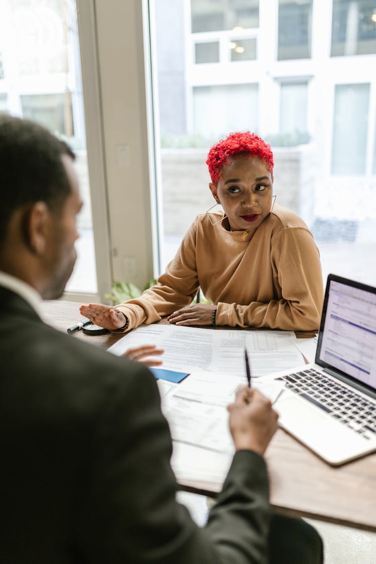 A Woman Working With A Colleague At An Office