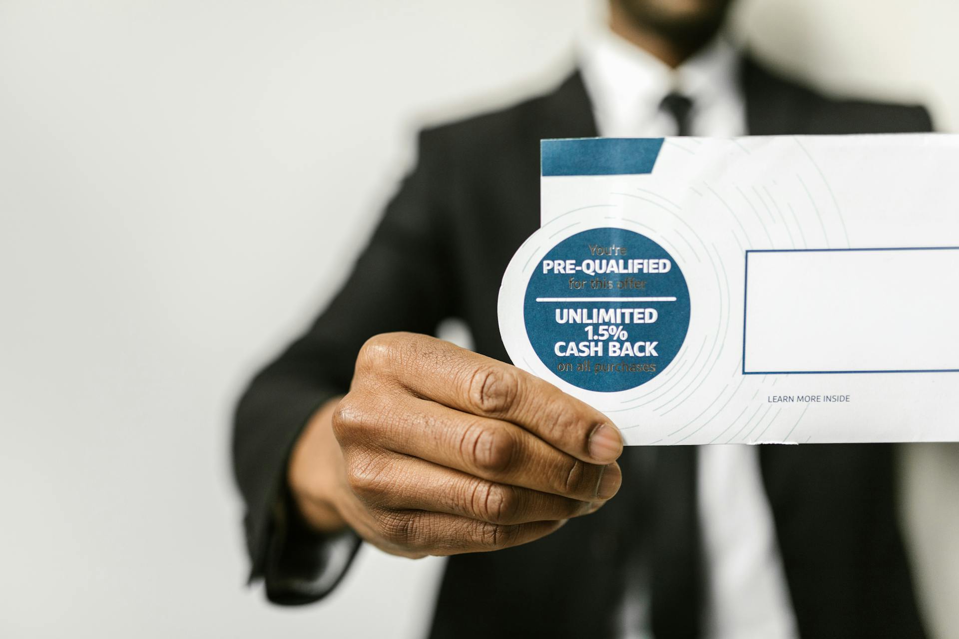 Person in Black Suit Holding an Envelope